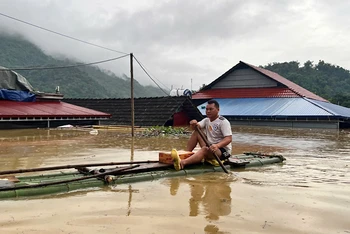 Một hộ dân ở xã Nam Cường, huyện Chợ Đồn di chuyển qua nước ngập bằng bè tre đi nhận nhu yếu phẩm hỗ trợ. (Ảnh: ĐÌNH HỢI).