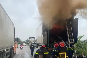 Lực lượng chức năng tháo rời đầu ô-tô kéo container chứa hàng hóa phát sinh hỏa hoạn.