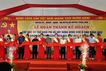 Các đại biểu cắt băng, hoàn thành xây dựng nhà ở cho đồng bào sinh sống trên sông ở huyện Thiệu Hóa lên bờ định cư.