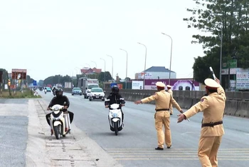 Cảnh sát giao thông phát lệnh dừng phương tiện để kiểm tra hành chính.