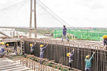 Công nhân thi công công trình cầu Mỹ Thuận 2 đẩy nhanh tiến độ để hoàn thiện cầu. (Ảnh BÁ DŨNG)