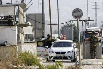 Binh lính Israel canh gác tại trạm kiểm soát Hawara ở Bờ Tây.