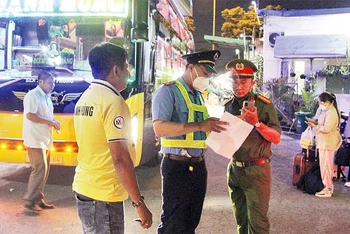 Thanh tra giao thông, Sở Giao thông vận tải phối hợp Công an phường Tam Bình, thành phố Thủ Đức kiểm tra một điểm “xe dù”có xe khách hoạt động trên Quốc lộ 1A. (Ảnh THẾ ANH)