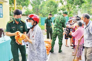 Các chiến sĩ Đồn Biên phòng Nhơn Hưng tặng gạo cho người nghèo.