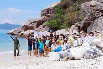 Du khách tham gia hoạt động nhặt rác trên bãi biển do khu nghỉ dưỡng Six Senses Ninh Van Bay tổ chức. (Ảnh UYÊN NGUYỄN)
