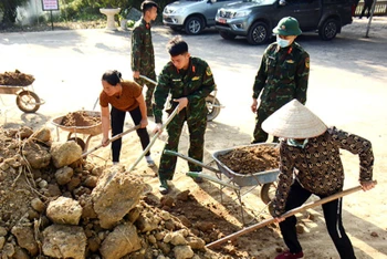Cán bộ, chiến sĩ Lữ đoàn Xe tăng 409 (Quân khu 1) giúp nhân dân thôn Bo Chợ, xã Đông Sơn, huyện Yên Thế (Bắc Giang) dọn vệ sinh.
