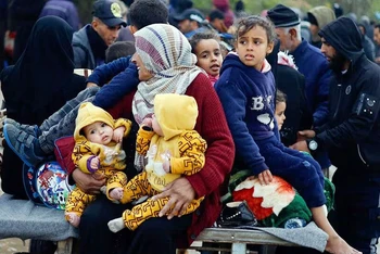 Người Palestine chạy khỏi khu vực giao tranh ở Gaza. (Ảnh REUTERS)