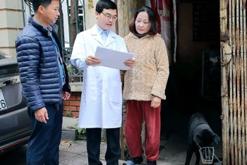 Cán bộ Trạm Y tế phường Thanh Nhàn, quận Hai Bà Trưng, Hà Nội tuyên truyền, hướng dẫn người dân phòng ngừa bệnh dại trên chó, mèo. (Ảnh HUY HOÀNG)