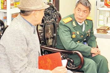 Trung úy Ngô Văn Chiến, Chủ tịch Hội cựu doanh nghiệp, doanh nhân cựu chiến binh huyện Yên Phong (người mặc quân phục) chuyện trò cùng tác giả.