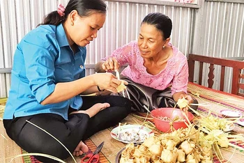 Bà Néang Phương (bên phải) dạy phụ nữ Khmer cách làm bánh kà tum.