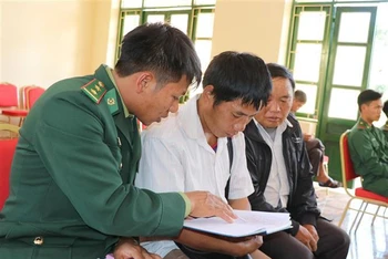 Chiến sĩ Đồn biên phòng Nậm Kè (Bộ đội Biên phòng tỉnh Điện Biên) trao đổi nội dung tuyên truyền, phổ biến pháp luật cho các trưởng bản. (Ảnh: TTXVN)