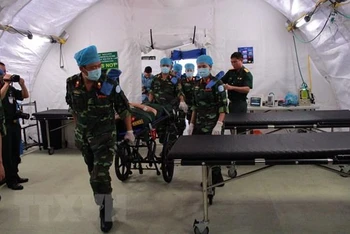 Các chiến sĩ 'mũ nồi xanh' Việt Nam diễn tập xử lý tình huống y tế trên bộ trang bị Bệnh viện dã chiến cấp 2 số 1. (Ảnh: TTXVN)