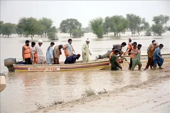 Người dân sơ tán khỏi khu vực ngập lụt ở tỉnh Punjab, Pakistan ngày 27/8/2022. (Ảnh: THX/TTXVN)