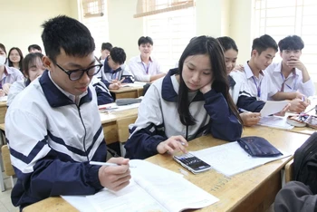 Học sinh Vũ Thế Sơn (ngồi đầu bàn bên trái) trong giờ học tại trường.