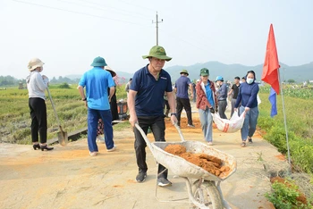 Cán bộ các cơ quan tỉnh Tuyên Quang cùng người dân làm đường giao thông nông thôn ở xã Thiện Kế, huyện Sơn Dương.