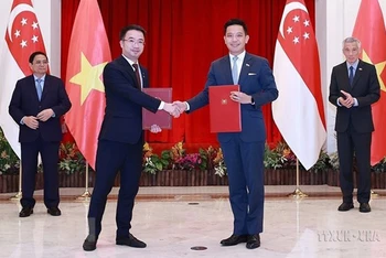 Thủ tướng Phạm Minh Chính và Thủ tướng Singapore Lý Hiển Long chứng kiến lễ trao văn kiện hợp tác giữa hai nước tại Singapore ngày 9/2/2023. (Ảnh minh họa: TTXVN)