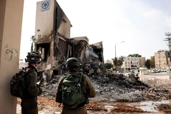 Lính Israel nhìn đống đổ nát của 1 đồn cảnh sát, nơi đã diễn ra giao tranh với các tay súng Hamas ở miền Nam Israel hôm 8/10. Ảnh: Reuters