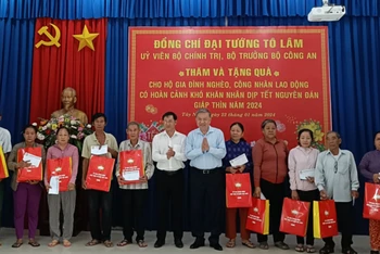 Bộ trưởng Tô Lâm tặng quà và chúc tết các hộ gia đình nghèo. (Ảnh: Báo Công an nhân dân)