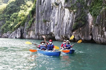 Khách du lịch quốc tế trong tour du lịch tham quan chèo thuyền kayak tại Vịnh Hạ Long. (Ảnh: NGHĨA HIẾU)