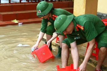 Đoàn viên thanh niên Công an tỉnh Quảng Bình giúp trường học vùng lũ vệ sinh trường lớp, lau rửa bàn ghế.