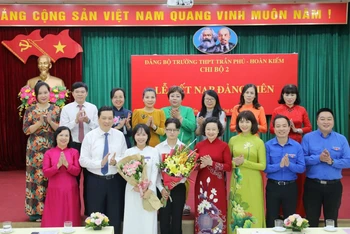 Các đại biểu Thành ủy Hà Nội, Quận uỷ Hoàn Kiếm chúc mừng hai đảng viên trẻ là học sinh lớp 12 của Trường Trần Phú-Hoàn Kiếm. (Ảnh: Thế Đại.)