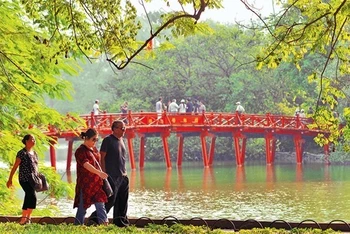 Khách du lịch nước ngoài đi dạo bên hồ Hoàn Kiếm. Ảnh: Duy Linh.