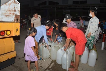 Người dân xã Tân Phước, huyện Gò Công Đông (Tiền Giang) đến lấy nước miễn phí từ các nhà hảo tâm, mạnh thường quân. (Ảnh: Nguyễn Sự)