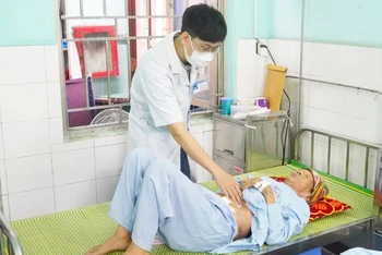 Bác sĩ thăm khám cho bệnh nhân hơn 100 tuổi sau ca phẫu thuật thành công.