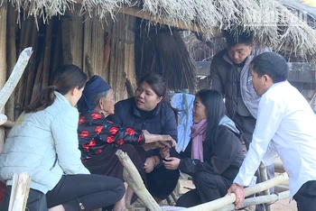 Thành viên tổ dân vận cơ sở huyện Nậm Pồ trao quà tết tặng bà Giàng Thị Dua ở bản mốc 4, xã Nậm Tin.