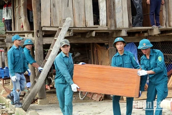 Dân quân và nhân dân xã Thanh Hưng, huyện Điện Biên hỗ trợ người dân di chuyển tài sản khỏi vùng nguy hiểm. (Ảnh: Trần Nhâm)