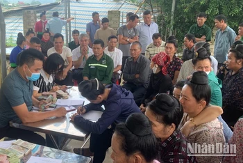 Cán bộ Công ty Cổ phần Cao su Điện Biên chi trả tiền góp đất cho người dân xã Mường Pồn (huyện Điện Biên).