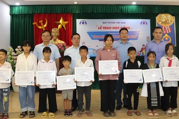 Đại diện lãnh đạo Quỹ Toyota Việt Nam và Ban An toàn giao thông tỉnh Điện Biên trao học bổng cho các em học sinh.