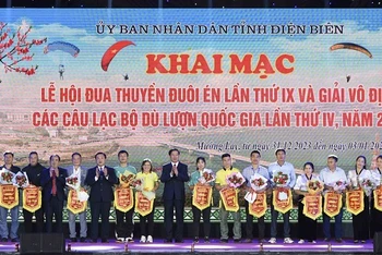Đại diện lãnh đạo tỉnh Điện Biên, lãnh đạo thị xã Mường Lay, tỉnh Điện Biên trao cờ lưu niệm cho các đội tham gia đua thuyền đuôi Én và Giải vô địch các câu lạc bộ dù lượn.