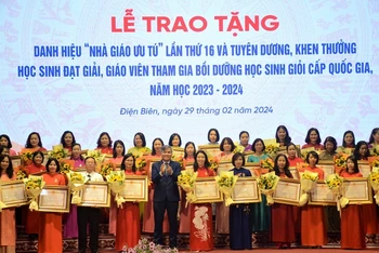Đồng chí Lò Văn Tiến, Phó Chủ tịch Ủy ban nhân dân tỉnh Điện Biên trao danh hiệu "Nhà giáo Ưu tú" tặng các thầy giáo, cô giáo.