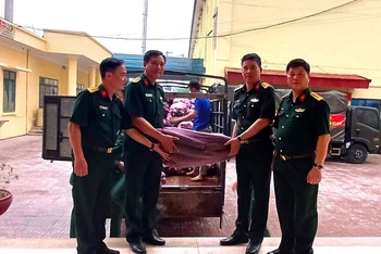 Đại diện cán bộ Ban Chỉ huy quân sự huyện Nậm Pồ trao bí xanh để các bộ phận chế biến phục vụ lực lượng diễu binh, diễu hành.
