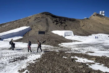 Những người đi bộ qua con đường mới được phát hiện tại khu nghỉ dưỡng trượt tuyết Glacier 3000 ở Les Diablerets, Thụy Sĩ. Ảnh: Reuters.