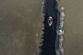 Thuyền đi qua một con nước hẹp ở hồ Titicaca, Bolivia, ngày 3/8. Ảnh: Reuters.