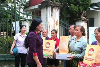 Chủ tịch Ủy ban Mặt trận Tổ quốc Việt Nam thành phố Hà Nội Nguyễn Lan Hương tặng quà và động viên người dân vùng lũ.