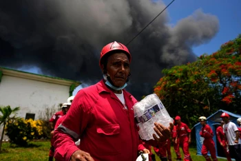 Một nhân viên cứu hỏa với gương mặt thất thần khi chứng kiến vụ hỏa hoạn. (Ảnh: El País)