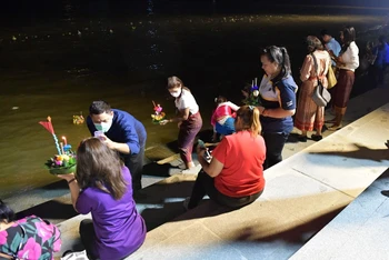 Người dân thực hiện nghi lễ thả đèn hoa đăng bên bờ sông Chao Phraya. 