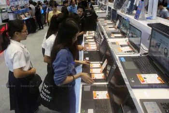 Các sinh viên đang tìm hiểu các loại máy tính xách tay trưng bày tại một hội chợ công nghệ. (Ảnh: Bưu điện Bangkok)