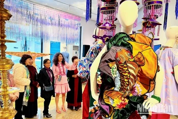Nhà thiết kế Thủy Nguyễn (váy hồng) giới thiệu các thiết kế với khách tham quan tại triển lãm.