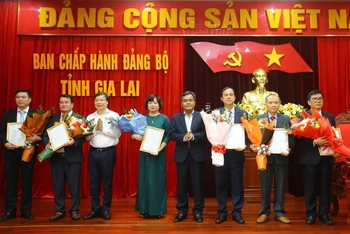 Bí thư Tỉnh ủy Gia Lai Hồ Văn Niên và Chủ tịch Ủy ban nhân dân tỉnh Gia Lai Trương Hải Long trao quyết định và tặng hoa chúc mừng các đồng chí vừa được điều động, bổ nhiệm.