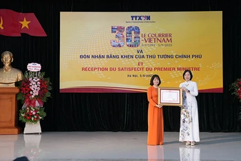 Tổng Giám đốc Vũ Việt Trang đã trao Bằng khen của Thủ tướng Chính phủ tặng Báo Le Courrier du Vietnam. (Ảnh: TTXVN)