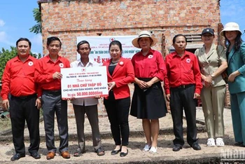 Trao biểu trưng hỗ trợ xây nhà Chữ thập đỏ cho ngư dân nghèo ở xã Đức Minh, huyện Mộ Đức. 
