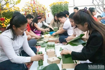 Khoảng 100 cán bộ, nhân viên người Việt Nam và Campuchia cùng tham gia gói bánh chưng. (Ảnh: Nguyễn Hiệp)