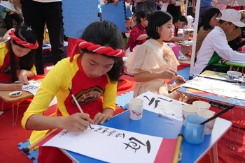 Các em học sinh huyện Bảo Thắng, tỉnh Lào Cai tham gia viết thư pháp.