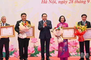 Phó Chủ tịch Thường trực Quốc hội Trần Thanh Mẫn trao Huân chương Lao động và tặng hoa chúc mừng các cá nhân. (Ảnh: Duy Linh)