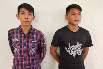 Công an đọc quyết định bắt tạm giam Nguyễn Minh Tâm (bên trái) và Trần Thanh Trọng. 