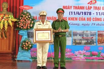 Đại tá Nguyễn Văn Tuấn (phải), Phó Cục trưởng Cục Cảnh sát quản lý trại giam, cơ sở giáo dục bắt buộc, trường giáo dưỡng (Bộ Công an) trao bằng khen của Bộ trưởng Công an cho đại diện tập thể Trại giam Kênh 7. (Ảnh: VĂN VŨ)